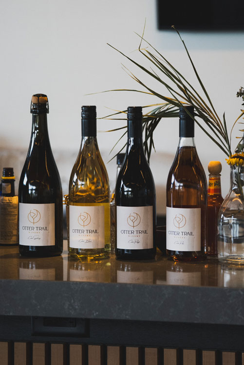 Lineup of Otter Trail Winery bottles on the bar