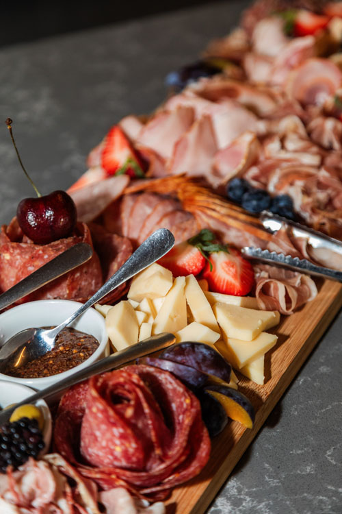 Charcuterie board with meats, cheeses, and fresh fruit