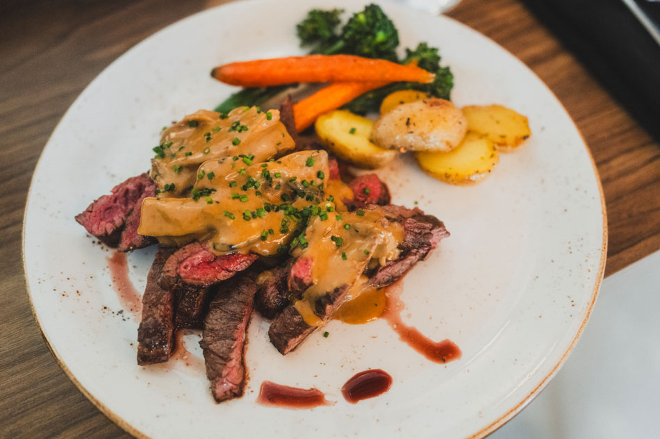 Sliced steak with mushroom sauce and roasted vegetables