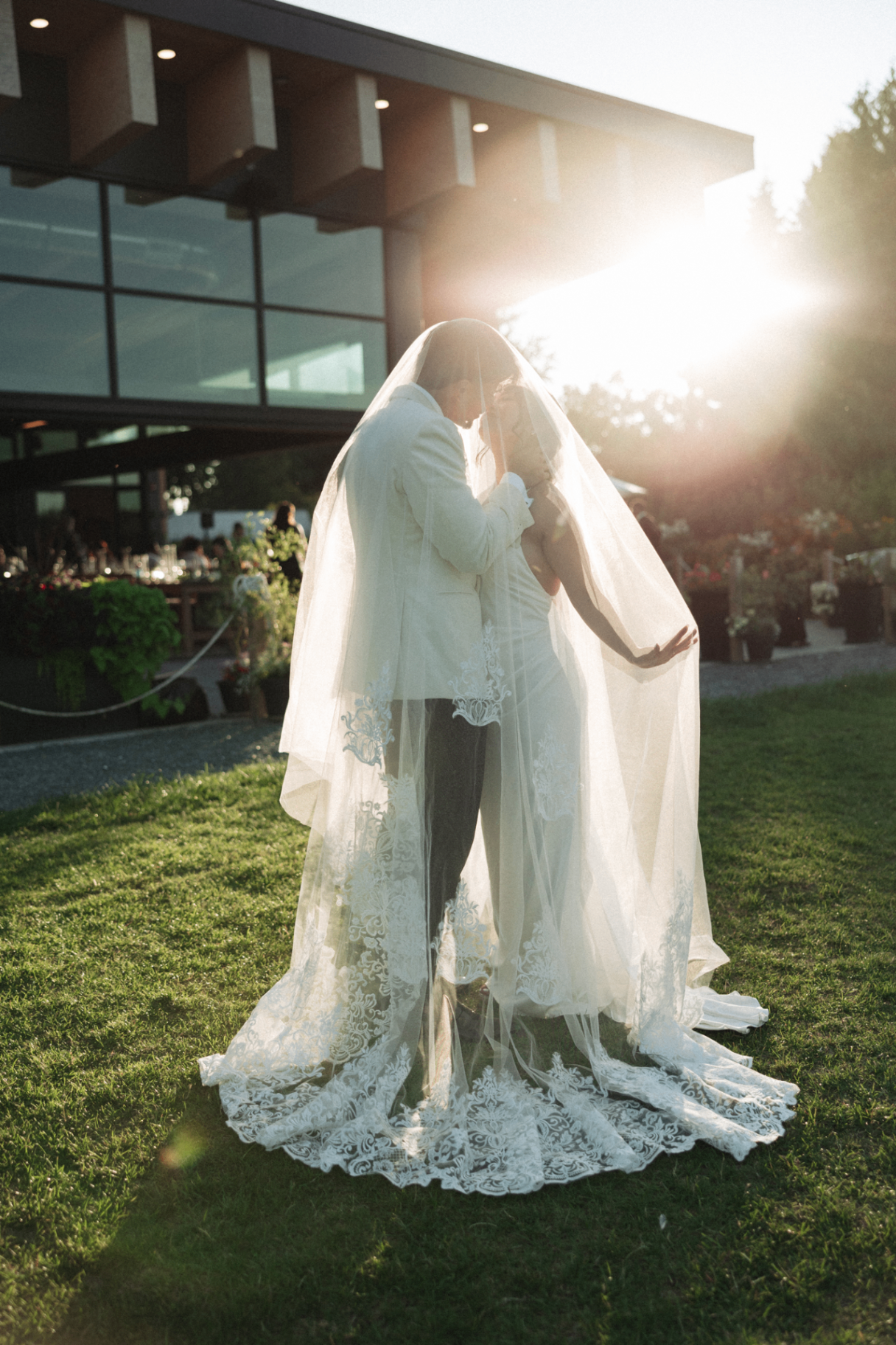 Couple under veil outside the venue at sunset