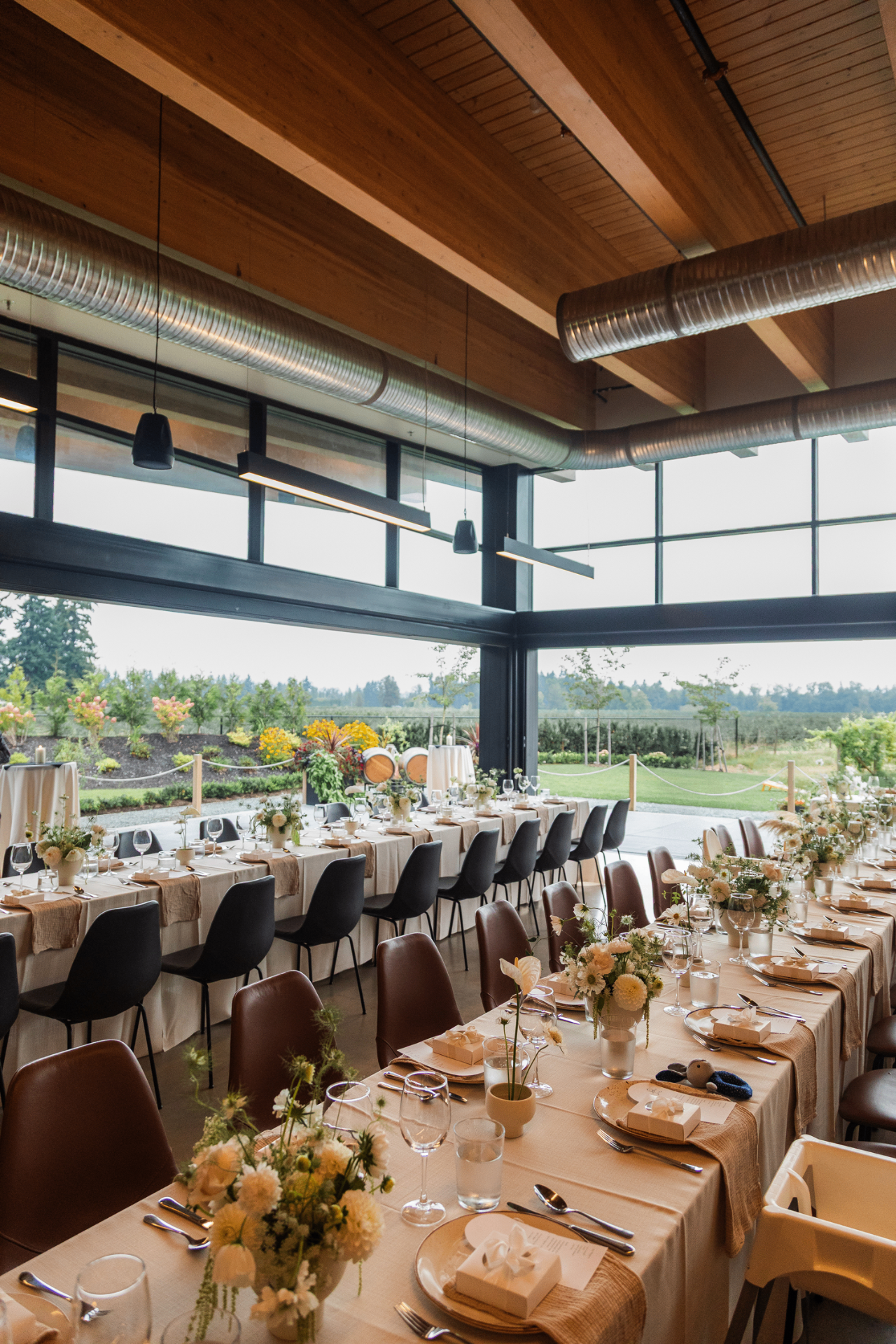 Long communal tables set for a wedding with vineyard views