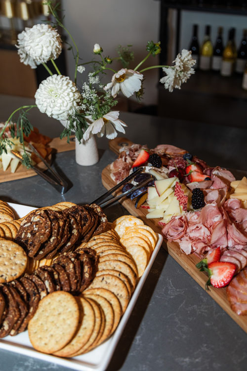 Charcuterie spread with crackers and floral centerpiece