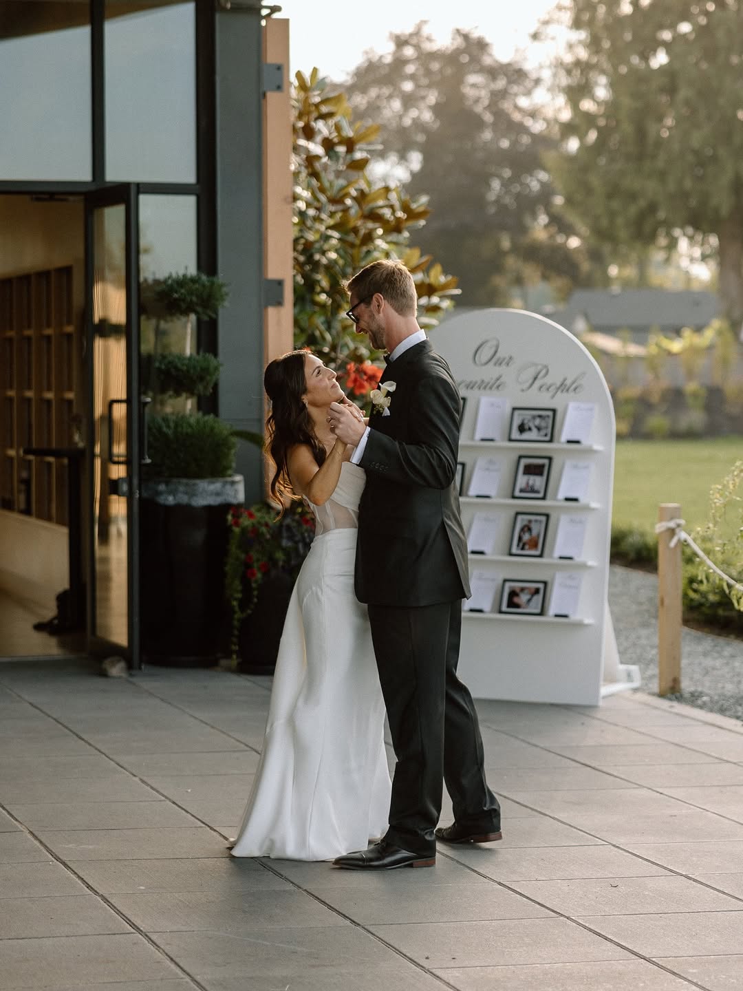 Couple embracing at the venue entrance beside the seating chart display